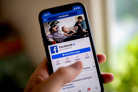 A smart phone is seen displaying the Facebook social media app